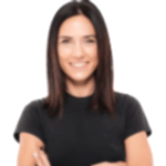 A woman with shoulder-length dark hair smiles at the camera. She is wearing a black short-sleeve shirt and has her arms crossed. The background, much like the aesthetic of fitted bedrooms, is plain white, giving the image a clean and simple look.