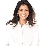 A woman with long, dark hair is smiling at the camera. She is wearing a white blouse and gold hoop earrings, embodying a casual, open and friendly demeanor. The background is plain white, reminiscent of the sleek design found in fitted bedrooms across London.